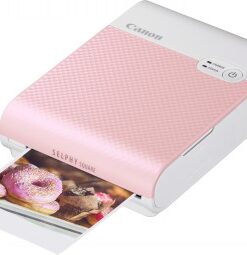 Canon Selphy Square QX10 compacte printer, roze Roze en witte Canon Selphy Square QX10-printer. De printer op de foto print een kleurrijke foto van donuts.