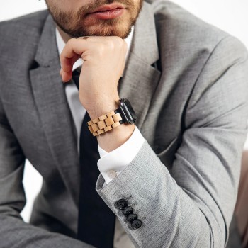 Havu Watches berkenhouten band voor Apple Watch, elegant en tijdloos design. Man in een grijs pak, die een Apple Watch draagt met een lichte houten band.
