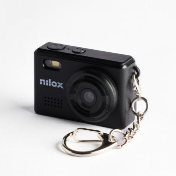 Zwarte Nilox Mini Action-camera op een tafel, met de lens en sleutelhangerbevestiging zichtbaar aan de voorkant.