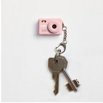 Nilox Mini Action Camera sleutelhanger, roze model Roze Nilox Mini Action Camera sleutelhanger met twee metalen sleutels eraan bevestigd tegen een witte achtergrond.