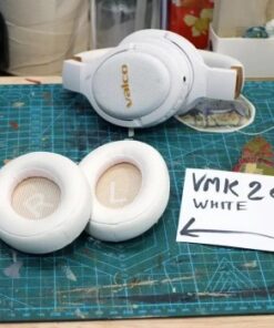 Twee witte verwisselbare oorkussens op een tafel, met witte Valco-hoofdtelefoon op de achtergrond.
