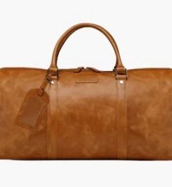 Dbramante1928 Kastrup 2 weekender-tas, stijlvolle tan-kleurige lederen tas. Lichtbruin lederen weekender-tas met handgrepen en afneembare schouderriem, van voren gefotografeerd.